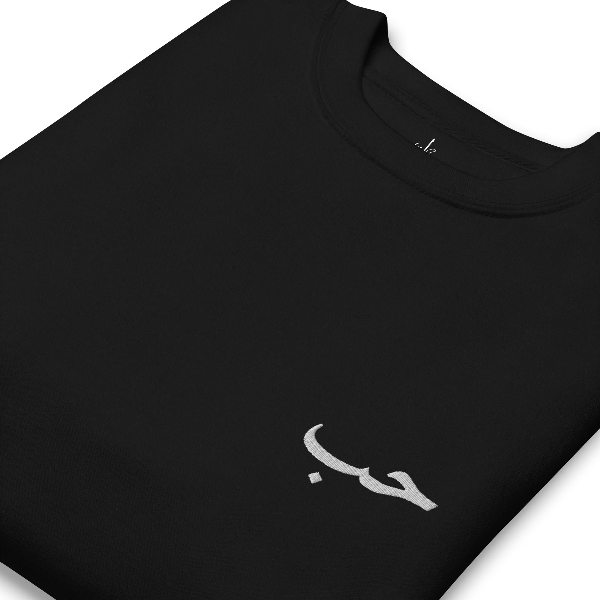 pull noir avec écriture arabe amour houb de la marque kalam plié