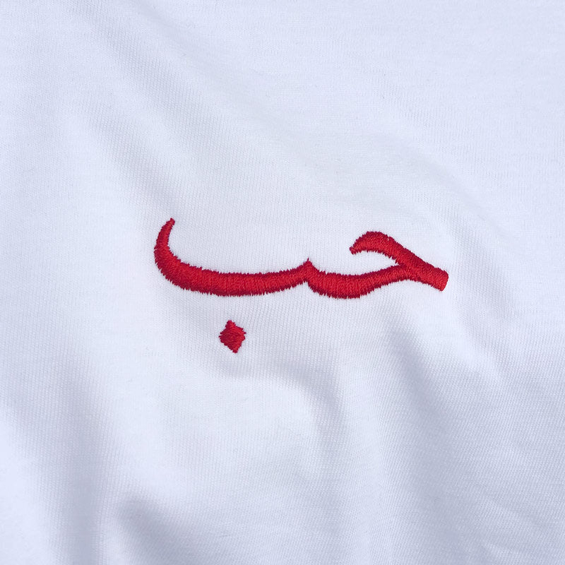 Broderie rouge en langue arabe signifiant amour sur un t-shirt kalam clothing